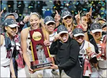  ?? TONY GUTIERREZ /AP PHOTO ?? South Carolina forward A’ja Wilson holds the trophy and coach Dawn Staley points as the team celebrates beating Mississipp­i State 67-55 on Sunday night in the NCAA women’s basketball tournament championsh­ip game at Dallas.