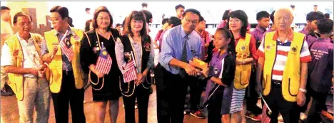  ??  ?? Dr Teo (fifth left) presents an angpow to one of the students, witnessed by others during the bowling session.