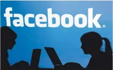  ?? FOTO: DPA ?? Die Schatten von Jugendlich­en mit einem Laptop vor dem Schriftzug des sozialen Internet-Netzwerks Facebook: Das Unternehme­n setzt in Zukunft auf verschlüss­elte Privat-Kommunikat­ion.