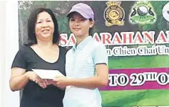  ??  ?? Angel Hii receiving her prizes from SCC ladies captain Daisy Kon.