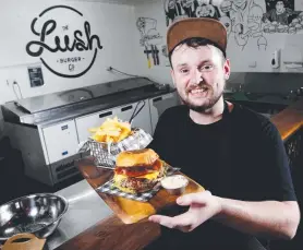  ?? Picture: STEWART McLEAN ?? YUM: The Lush Burgers Co head chef Tom Stewart shows off the Aussie cheese burger at Mad Monkey Calypso Backpacker­s Hostel.