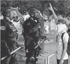  ?? BRENNAN LINSLEY, AP ?? Riot police block off the Albuquerqu­e Convention Center to anti- Trump protests after a rally Tuesday.