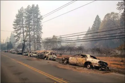 ?? The Associated Press ?? ABANDONED: Vehicles line the road Friday after a wildfire burned through Paradise, Calif.