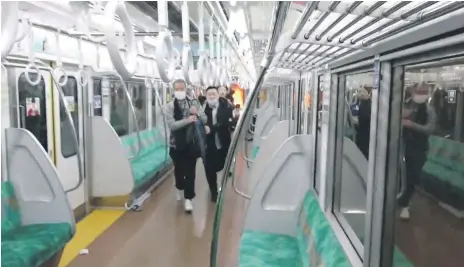  ?? Reuters; EPA ?? Passengers run through a carriage after a man wielding a knife set a fire; left, emergency personnel arrive at Kokuryo station, near where the attack happened
