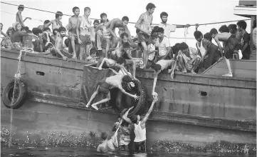  ??  ?? This file photo shows Rohingya migrants passing food supplies dropped by a Thai army helicopter to others aboard a boat drifting in Thai waters off the southern island of Koh Lipe in the Andaman sea. An army ‘Big Shot’ whose influence seeped across the...