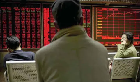  ??  ?? BEIJING: Chinese investors monitor stock prices on an electronic display in a brokerage house in Beijing yesterday. — AP