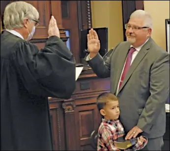  ?? WDN photo ?? Auglaize County Common Pleas Court Judge Frederick Pepple swears in Dave Bambauer as county commission­er during a ceremony on Monday.