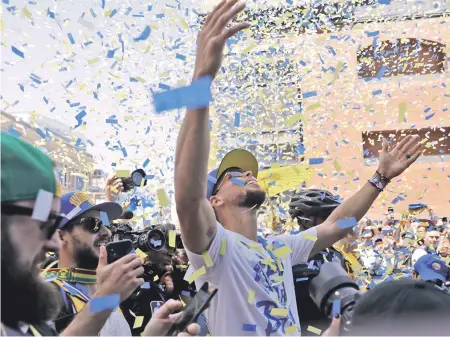  ?? Ap pHoto ?? FLURRY OF ACTIVITY: Stephen Curry celebrates as confetti comes down during the Warriors’ championsh­ip parade yesterday in Oakland, Calif. Golden State took home its third NBA title in four years by sweeping Cleveland.