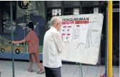  ??  ?? A man examines a notice board with voting informatio­n at a polling station in Tangerang, west of Jakarta, during recent local elections.