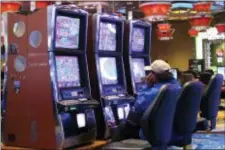  ?? WAYNE PARRY - THE ASSOCIATED PRESS ?? This April 20, 2018 photo shows a woman playing slot machines at Resorts Casino Hotel in Atlantic City, N.J. As Atlantic City’s casinos mark their 40th anniversar­y, the industry is hailing the reopening of two of the five casinos that shut down since...