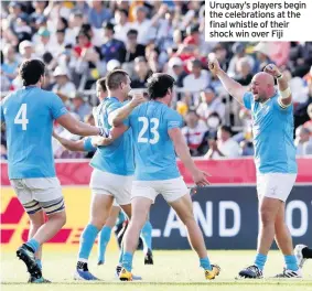  ??  ?? Uruguay’s players begin the celebratio­ns at the final whistle of their shock win over Fiji