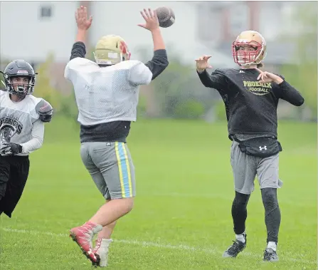  ?? DAVID BEBEE WATERLOO REGION RECORD ?? Resurrecti­on Phoenix boys’ senior football quarterbac­k Max LeDuc throws over the hands of linebacker Juvantha Crawford during practice Tuesday.