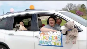  ??  ?? Jamie Rogers (front) and her family, including daughter Madison Rogers, 15, holding Rosco, joined the teacher parade March 29 through Pea Ridge, waving to students.
(NWA Democrat-Gazette/Annette Beard)