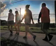  ?? GENE WALSH — DIGITAL FIRST MEDIA ?? Walkers stroll along the trails during the Solidarity Run at the Norristown Farm Park Wednesday.