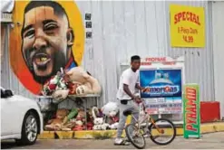  ??  ?? BATON ROUGE: Ronald Smith gets on his bicycle after stopping at the Triple S Food Mart, where Alton Sterling was shot by police one year ago, in Baton Rouge, La. —AP