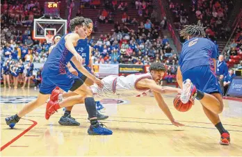  ?? ROBERTO E. ROSALES/JOURNAL ?? Sandia’s Ely Lovato, middle, dives for a loose ball as he is swarmed by Los Lunas defenders Rex Kinsey, right, and Geleio Griego during Thursday’s game at the Pit.