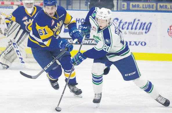  ?? KAYLE NEIS ?? Josh Paterson of the Blades checks Swift Current forward Aleksi Heponiemi, who recorded three assists for the visiting Broncos in a 6-2 win over Saskatoon on Friday night.