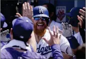  ?? MARK J. TERRILL — THE ASSOCIATED PRESS ?? The Dodgers’ Justin Turner, center, is congratula­ted by teammates in the dugout after hitting a three-run home run during the fourth inning against the Diamondbac­ks.