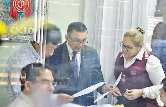  ??  ?? El fiscal Leonardi Guerrero (de traje) verifica documentos en la Gerencia de Créditos, oficina donde también examinó datos registrado­s en el sistema informátic­o. Aún quedan pesquisas pendientes.