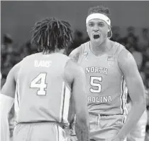  ?? ?? RJ Davis and Armando Bacot celebrate during No. 8 seed North Carolina’s win over No. 1 seed Baylor in an East Region second-round game Saturday. Baylor was the defending national champion.