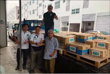  ??  ?? Wan (front, centre) shakes hands with the transporte­r for helping to send the essential items to Sri Aman.