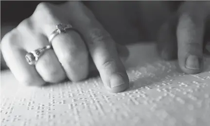  ?? PHOTOS: DARREN BROWN/OTTAWA CITIZEN ?? Diane Bergeron reads from a braille book in the Ottawa office Tuesday. She is happy Canada plans to join the Marrakesh Treaty, which is designed to make more reading materials available to people who can’t read printed material or computer screens.