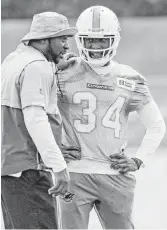  ?? AL DIAZ adiaz@miamiheral­d.com ?? Dolphins defensive assistant Patrick Surtain talks with cornerback Mackensie Alexander during practice.