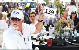  ?? Signal file photo ?? Ken Kurowski holds up a number indicating he wants to donate $100 at the 29th annual Taste of the Town at Mann Biomedical Park in Valencia in May 2017. The annual fundraiser is set to return to the Santa Clarita Valley on Sunday.