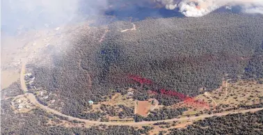  ?? JIM THOMPSON/JOURNAL ?? Fire retardant dropped by air tankers marks the trees near homes as the Dog Head Fire burns on Thursday.