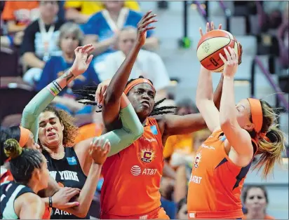  ?? SEAN D. ELLIOT/THE DAY ?? Connecticu­t Sun guard Rachel Banham, right, pulls down a rebound over teammate Jonquel Jones, center, and New York Liberty center Amanda Zahui B. in the second half of Wednesday’s WNBA game at Mohegan Sun Arena. The Sun won 70-63.