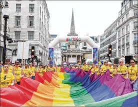  ?? TRISTAN FEWINGS / GETTY IMAGES FOR PRIDE IN LONDON ?? A giant rainbow-colored flag gets carried in London on Saturday. Alison Camps, cochair of Pride in London, said, “It’s vital that we remember that Pride is not just one day a year.”