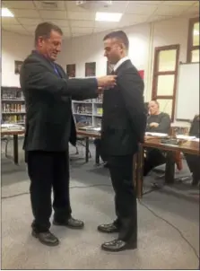  ?? JEFF MILL — THE MIDDLETOWN PRESS ?? Tim DeRoehn gets pinned by his father, Michael DeRoehn, a career firefighte­r in Waterbury.