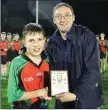  ??  ?? Brendan Lawrence presents Christy Mooney of St Kevin’s with the Wicklow People sponsored Man of the Match award.