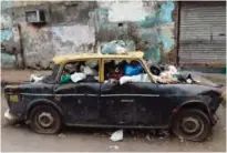  ??  ?? A Premiere Padmini taxi used as a garbage vat is seen along a street in the Indian city of Mumbai.— AFP photos