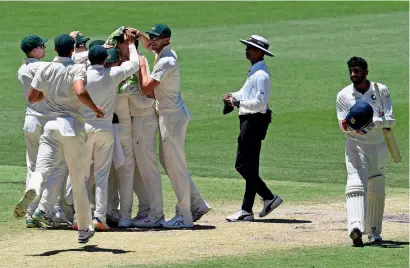  ?? AFP ?? Australian players celebrate their win as India’s Jasprit Bumrah (right) walks off the field on day five of the second Test. —