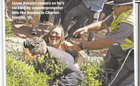  ??  ?? Jason Kessler cowers as he’s tackled by counterpro­tester into the bushes in Charlottes­ville, Va.