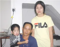  ??  ?? Bang Ajang and his wife Jenny Sindan with their handicappe­d boy, Fabian Jiu.