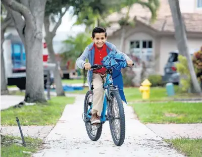  ?? SUSAN STOCKER/SOUTH FLORIDA SUN SENTINEL ?? Noman Mujtaba, 10, who recently arrived from Afghanista­n, rides a new bike he received as a gift from Broadway director and children’s book author Neil Goldberg on Wednesday in Davie.