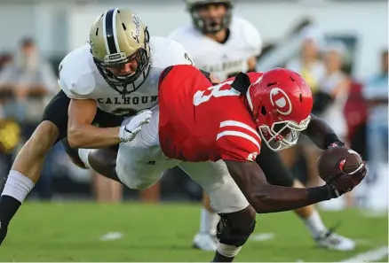  ?? STAFF PHOTO BY DAN HENRY ?? Dalton High School’s Zeke Cobb dives for a touchdown as Calhoun’s Brannon Spector (3) attempts to stop him Friday night at Harmon Field at Bill Chappell Stadium. Cobb had a pair of touchdown catches as the Catamounts topped nonregion rival Calhoun 28-13.