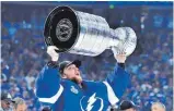  ?? FOTO: JULIO CESAR AGUILAR/AFP ?? Andrei Wassilewsk­i von den Tampa Bay Lightning reißt den Stanley Cup in die Höhe.