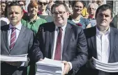  ?? ROSA WOODS/STUFF ?? Senior MPs James Shaw, Grant Robertson and Chris Bishop receive a 70,000-signature petition calling for a ban of semi-automatic weapons, in the aftermath of the Christchur­ch terror attacks five years ago. The current Government is proposing a new Arms Act, and the ban on such weapons may be revisited.