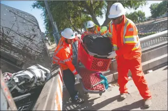  ?? NEWS-SENTINEL PHOTOGRAPH­S BY BEA AHBECK ?? Caltrans workers clean up the homeless encampment along Highway 99 in Lodi on Thursday morning.