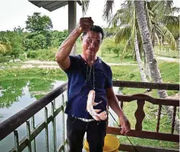  ??  ?? A resident from a Hakka village in Machap Baru, Malacca, showing off his catch of the day.