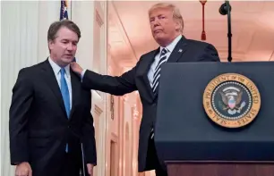  ?? AFP ?? President donald Trump pats brett Kavanaugh on the back during a ceremonial swear-in at the white House in washington.—