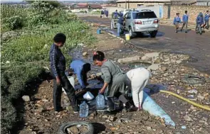  ?? Picture: Alaister Russell ?? People in Emalahleni collect water from a burst pipe. The writers say two bills approved by the National Assembly will profession­alise the public sector and enhance service delivery.