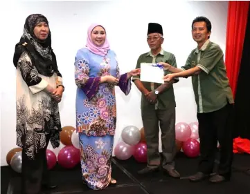  ??  ?? Sharifah Hasidah (second left) presents a certificat­e to a villager, witnessed by Sarawak Administra­tive Officer Suraijah Mainol (left) and Penghulu Mornie Abone.