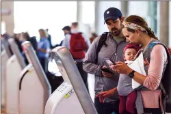  ?? SHAFKAT ANOWAR/DALLAS MORNING NEWS/TNS ?? Cheryl Steifel, of Dallas, carrying her four-month-old daughter Emery, checks in for their flight to Nashville as her husband Zach Steifel watches on Tuesday, April 19, 2022, at Dallas Love Field Airport in Dallas, Texas.