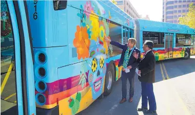  ?? ADOLPHE PIERRE-LOUIS/JOURNAL ?? Albuquerqu­e Mayor Tim Keller, left, and Chief Operating Officer Lawrence Rael on Friday announced that the longdelaye­d Albuquerqu­e Rapid Transit project, with brightly colored turquoise buses, would begin service on Nov. 30.