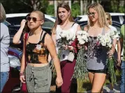  ?? JOE RAEDLE/GETTY IMAGES ?? Emma González, left, a senior at Marjory Stoneman Douglas High School, and others walk to campus Feb. 25, 11 days after the shooting there that killed 17 people. González has become the face of the gun control debate.