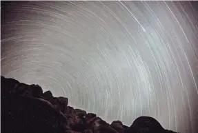  ?? TREVOR HUGHES/USA TODAY ?? The stars seem to wheel overhead in this long exposure photograph centered on Polaris, the North Star, just below the horizon. Polaris, which sits in the north sky, has long been an important navigation­al point for sailors and explorers. This “spin”...